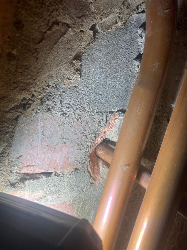 Gas pipe passing through masonry without a protective sleeve