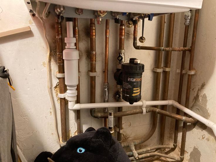 Pipework and magnetic filter beneath the new Potterton combi boiler in Bushey