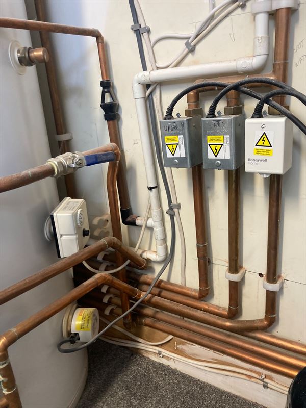 Pipework and controls beside the hot-water cylinder in Borehamwood