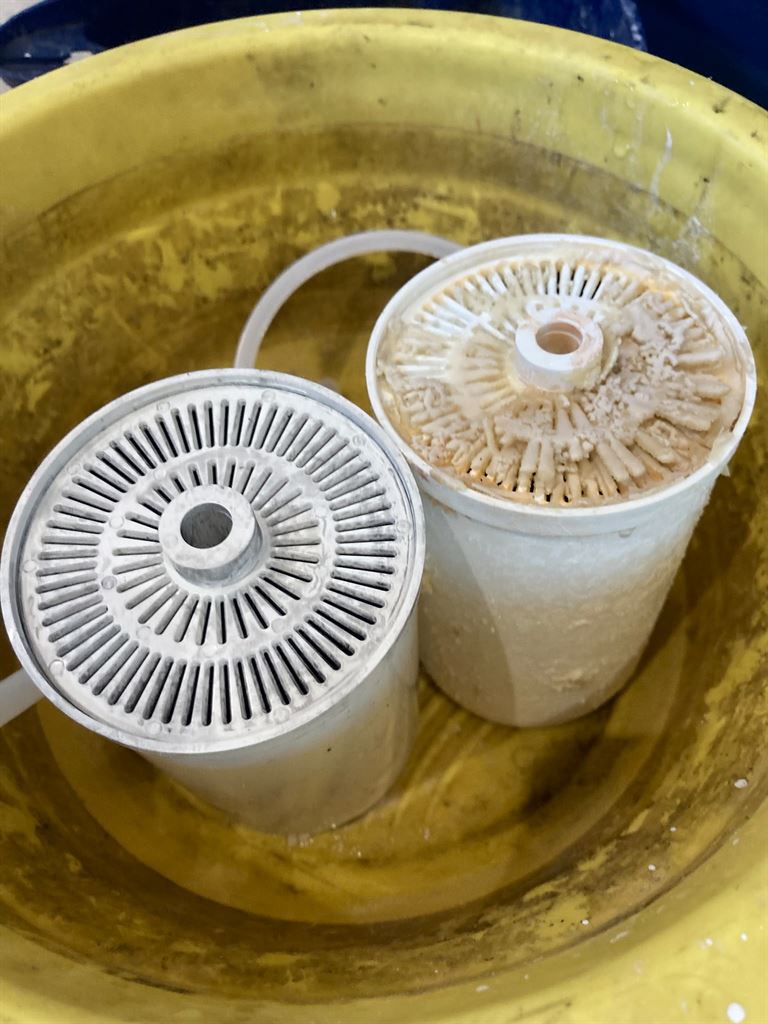 Two Quooker internal components showing different levels of limescale deposits