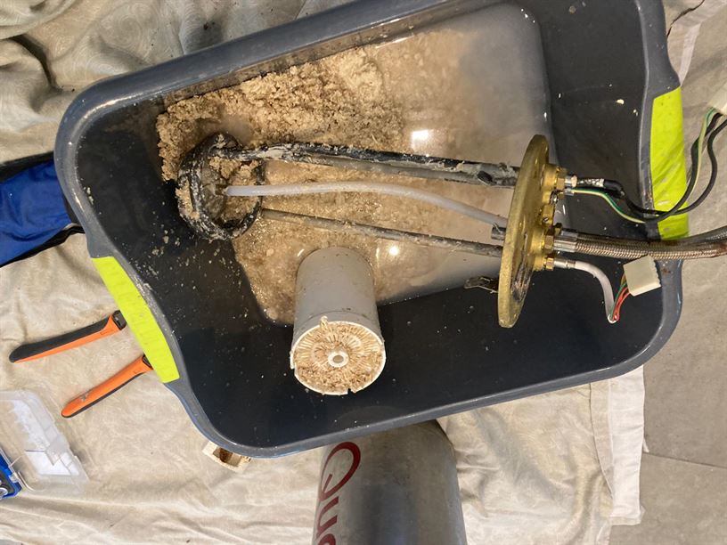 Quooker internal components and accumulated deposits in a service tray