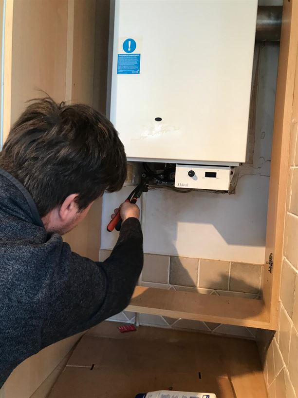 Engineer working on the old Potterton boiler before replacement in Pinner HA5