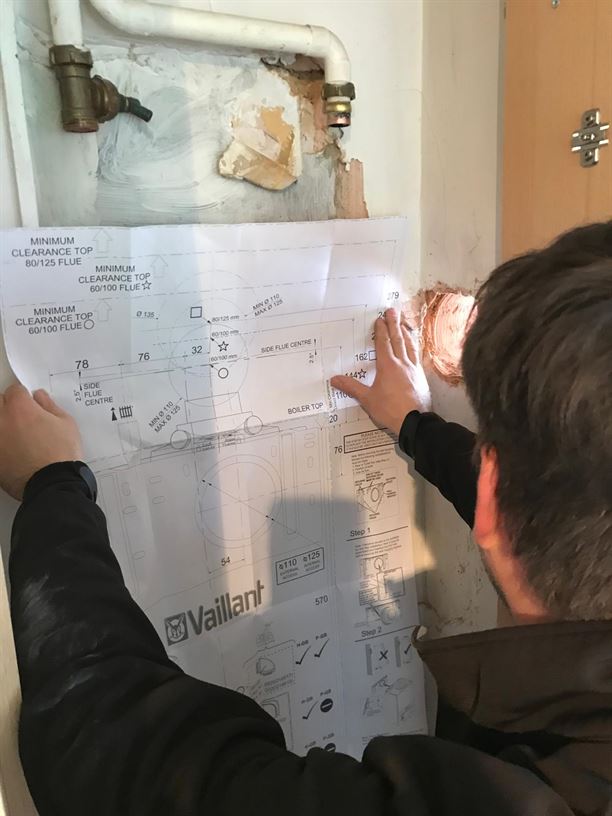 Engineer positioning the Vaillant installation template in Pinner
