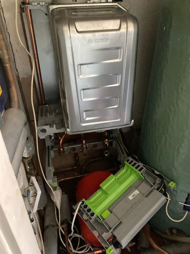 New Worcester Bosch boiler with its controls open during installation